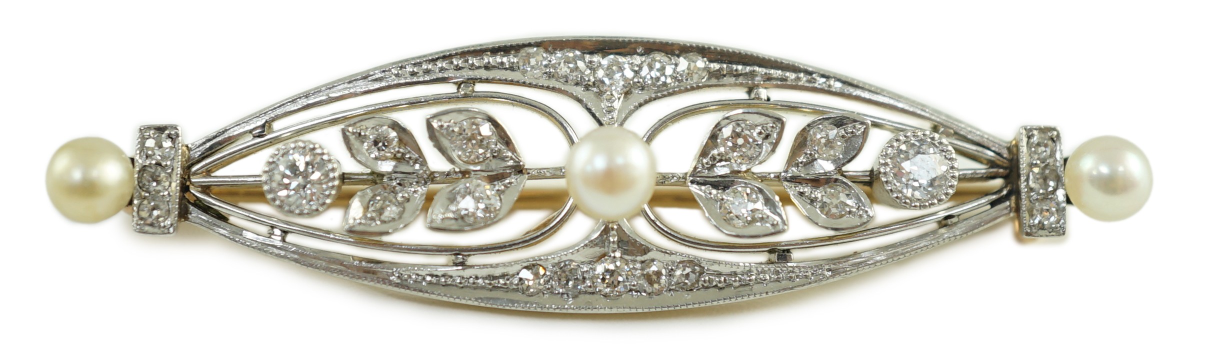 An early to mid 20th century gold and platinum, pearl and round cut millegrain set diamond cluster oval brooch